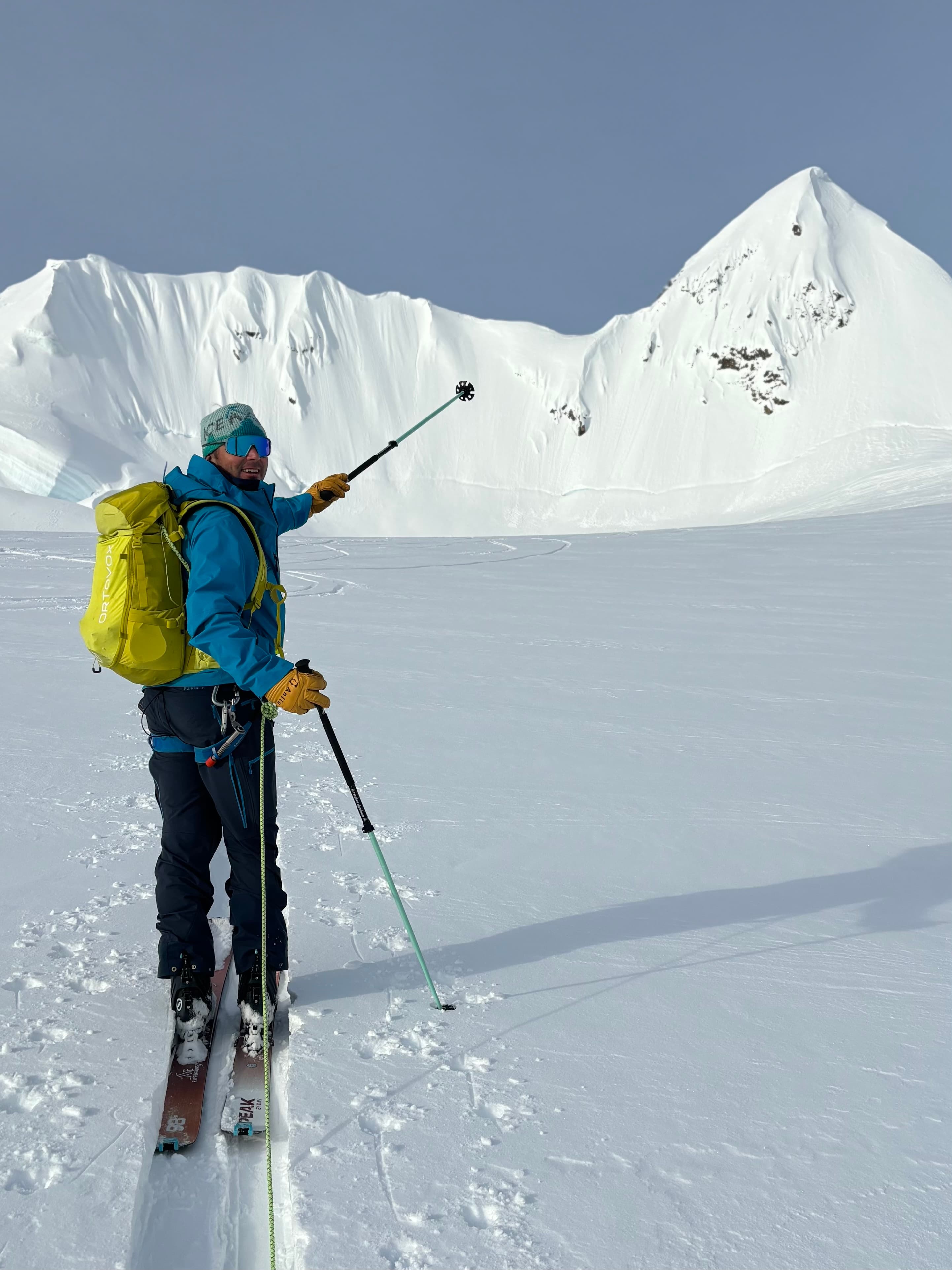 Chris Davenport standing on a glacier with a peak behind