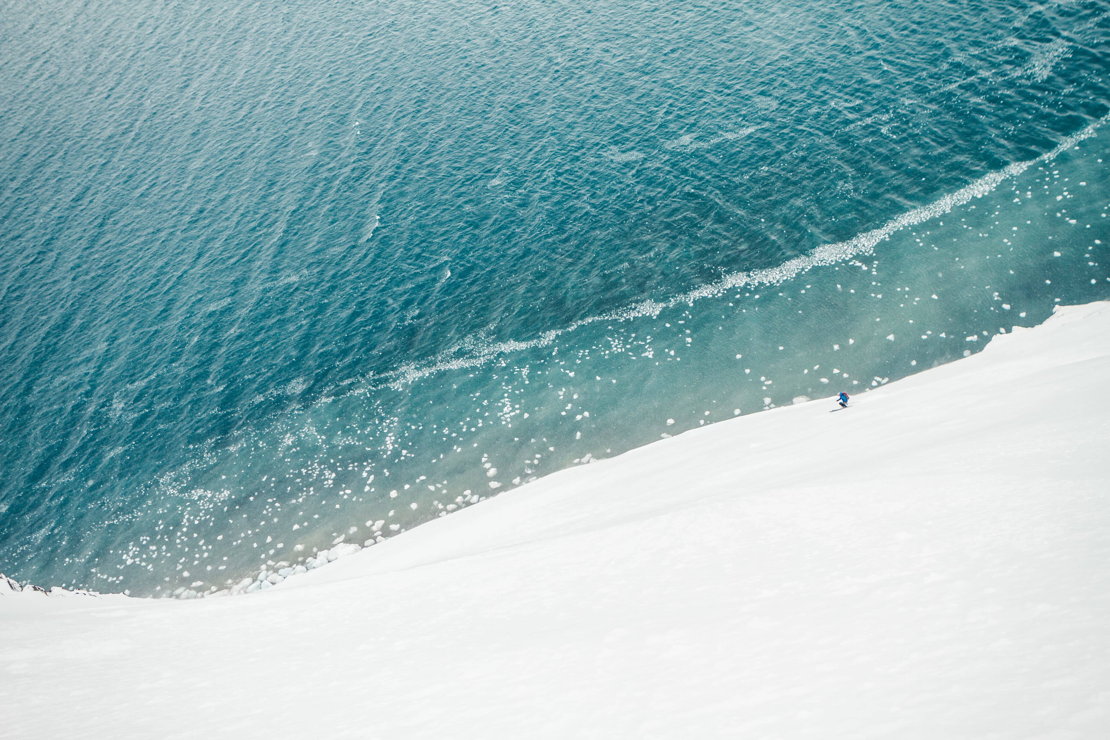 Solitary skier at the edge of snow and Antarctic ocean