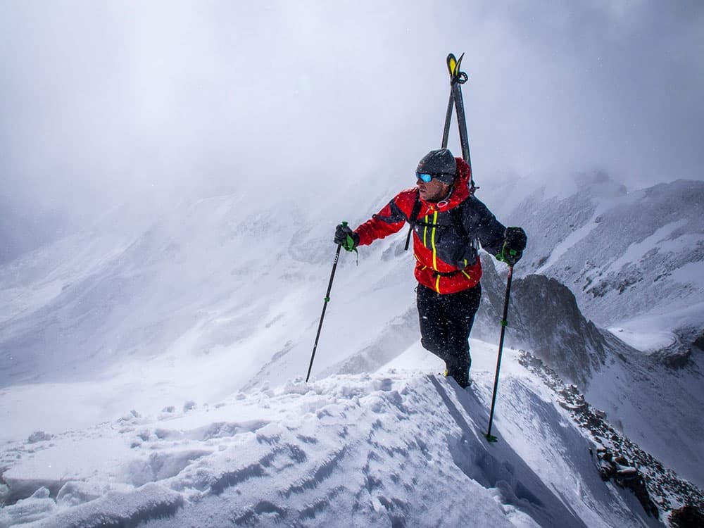 Chris Davenport on a stormy Colorado ridge with skis