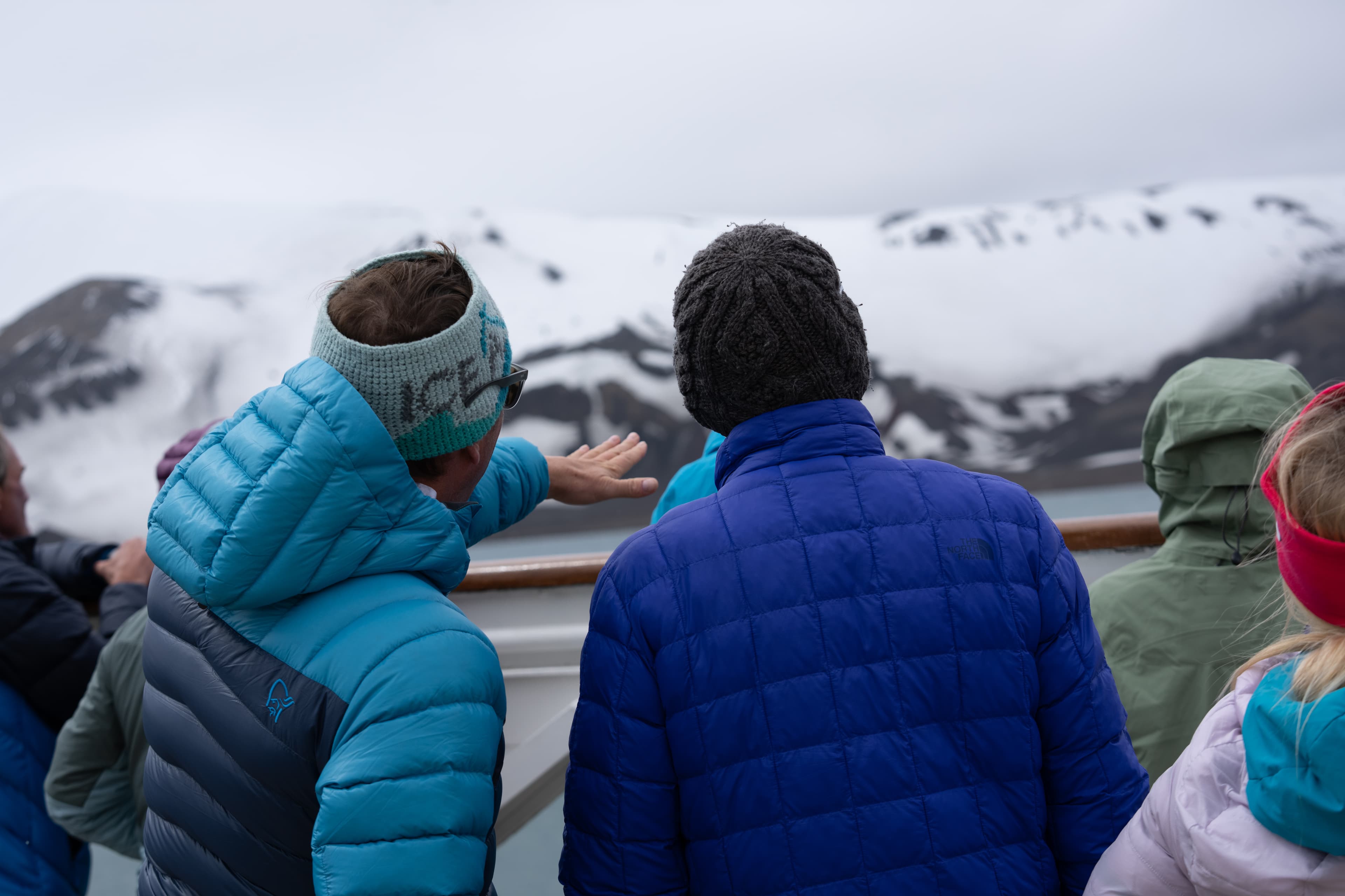 Guests on deck approaching Antarctic mountains
